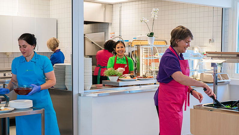 Damene kokkelerer på kjøkkenet i en Løvetann kantine.